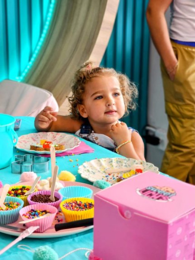 A young guest decorating treats at a Sweet Lich's party