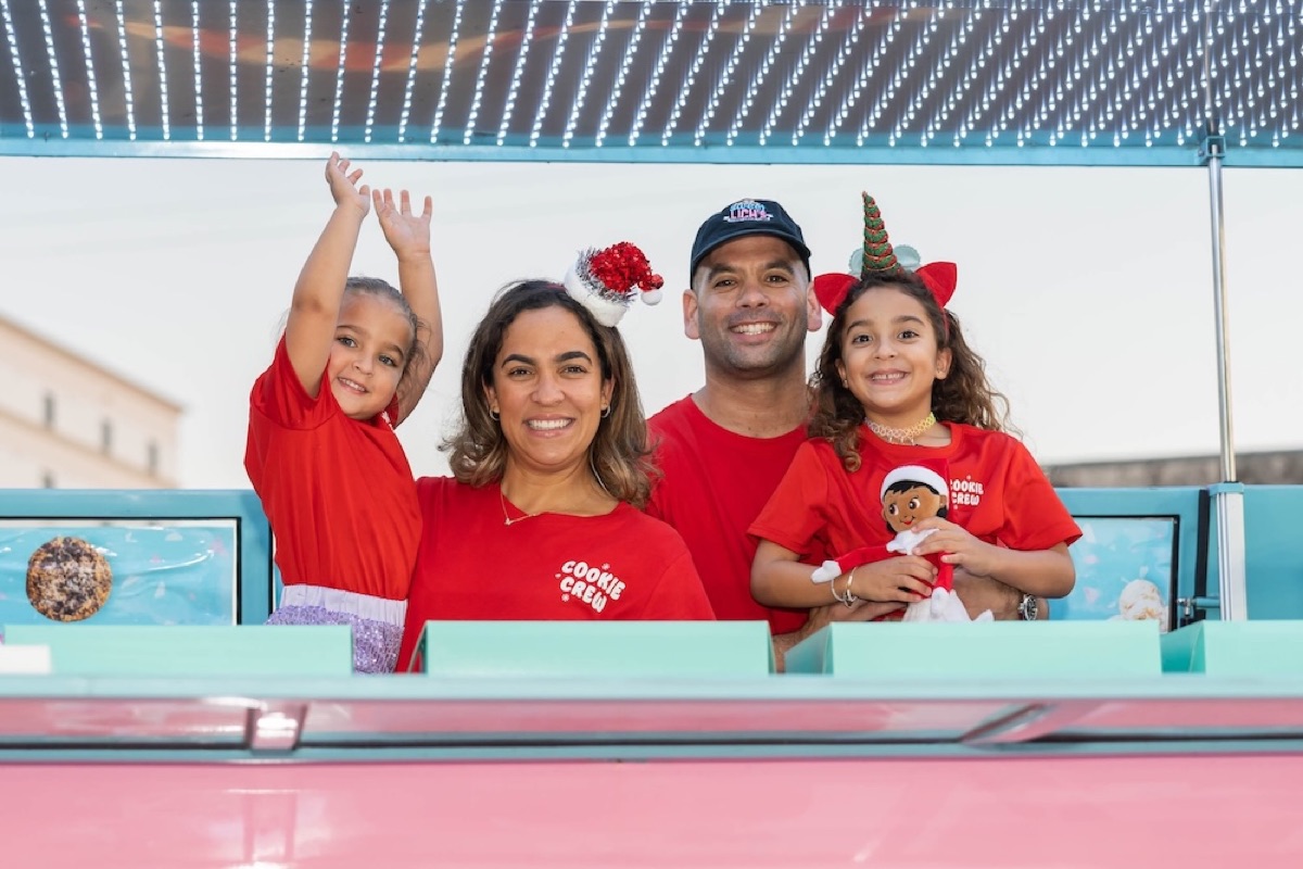 The Sweet Lich's family in front of their teal shop wall